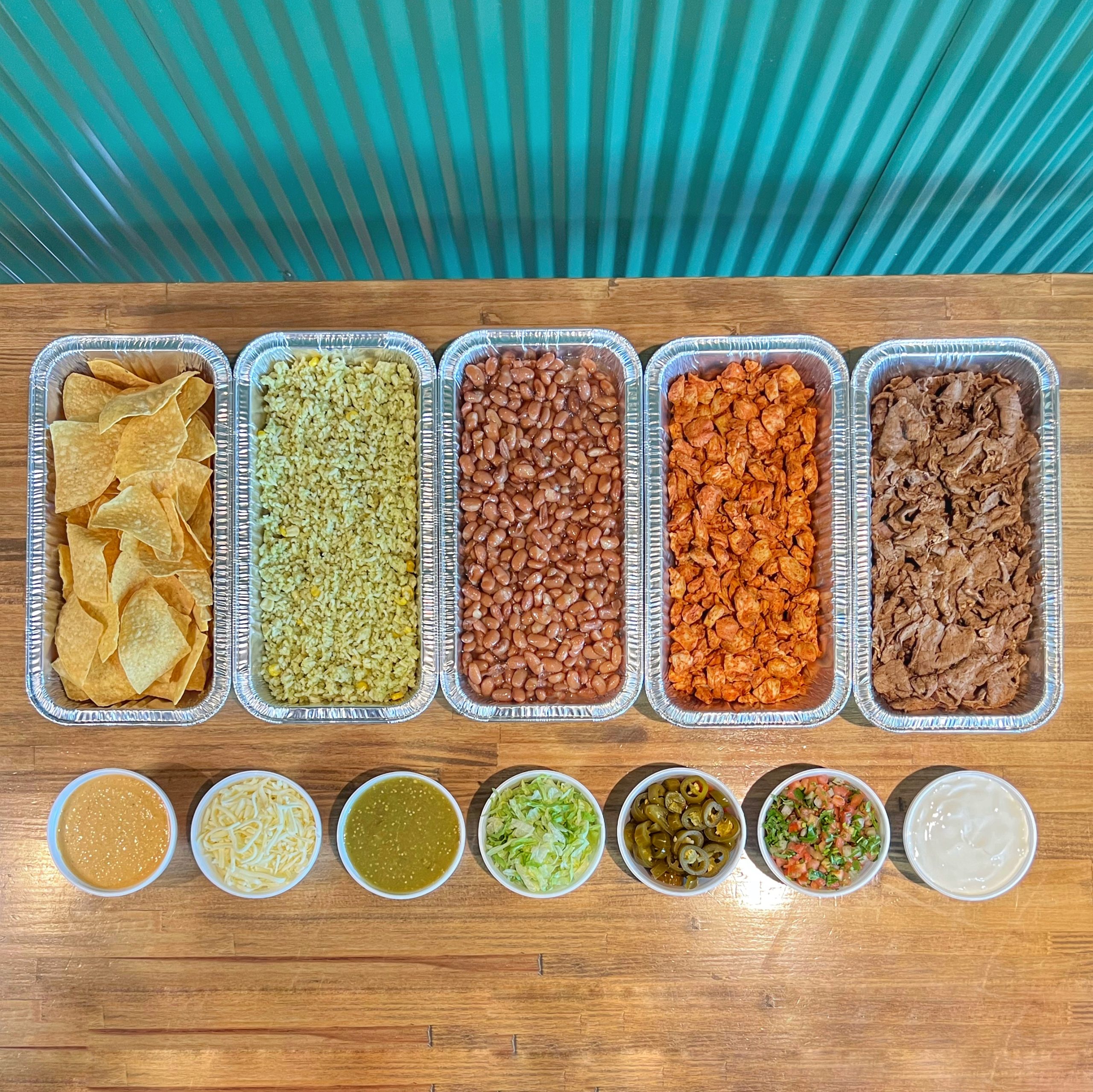 TNT’s bowl and nacho spread with chips, rice, beans, meats and toppings in catering trays